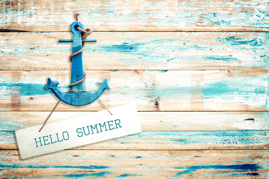 Vintage Hello summer sign hanging with anchor on old wooden blue paint background. vintage wood texture from beach in summer.