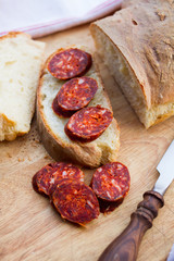 knife, fresh bread and sausage on the table
