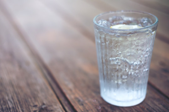 A glass of cold water and iced on wooden table
