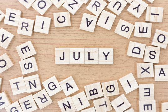 July words with wooden blocks on wooden floor..