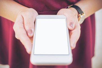 Mockup image of a woman holding white mobile phone with blank white screen   