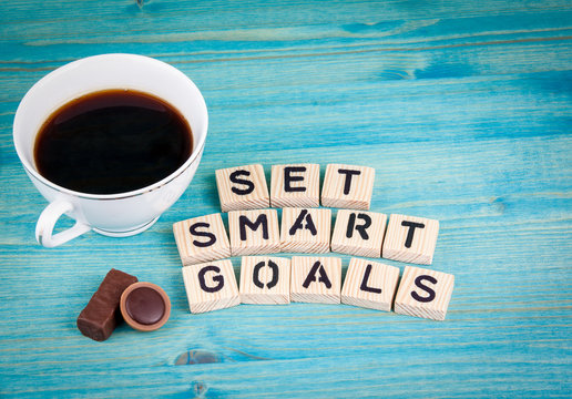 set smart goals. Coffee mug and wooden letters on wooden background.