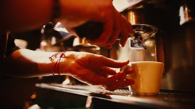 Close up shot of a barista preparing an espresso coffee in a bar. 