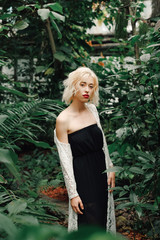 Obraz na płótnie Canvas Fashion model posing in tropical botanic garden