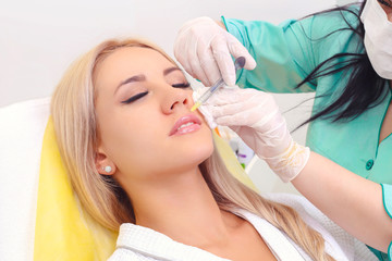 Fototapeta premium Injection in her lips and face.