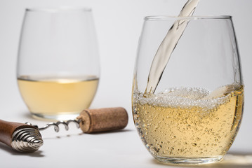 Pouring White Wine into Stemless Glasses