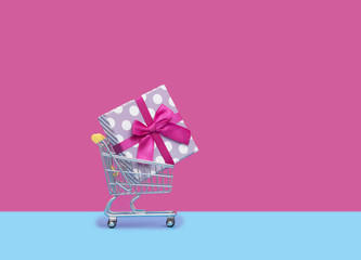 cute pink gift in cool shopping cart in front of the wonderful pink background