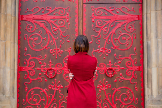 beautiful young woman hugging herself in front of the wonderful huge door in Poland