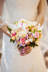 Wedding Flowers Roses Bouquet in Bride Hands with White Dress on Background