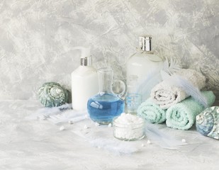 Spa set on a white marble table with a stack of towels, selective focus