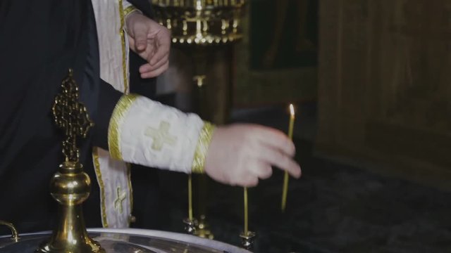 The priest lights the candles