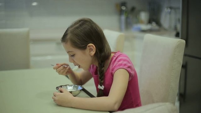 Girl eating ice cream in the kitchen