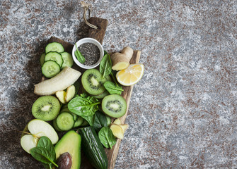 Food background. Detox green vegetables and fruits on a wooden board. Concept of a healthy, diet food. Top view, copy space