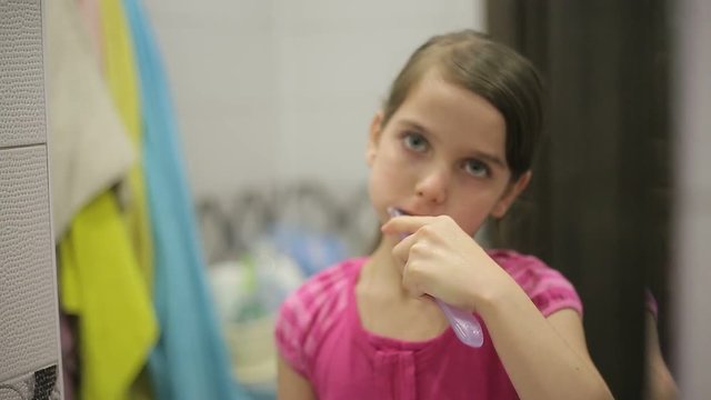 Girl brushing his teeth mirror