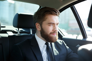 Fototapeta na wymiar Young smiling businessman sitting in a car