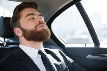 Business man sleeping in the back seat of a car - Powered by Adobe