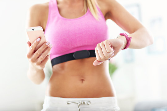 Sports woman using smart watch and checking her heart rate