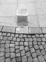 Black and white pavement close up with cement pillar
