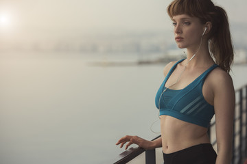 a woman runner is enjoying a morning sunrise in her sports outfit