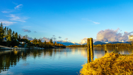 Obraz na płótnie Canvas Sunset over the Fraser River with old wooden pilings used to tie log booms at Brae Island near the historic town of Fort Langley, British Columbia