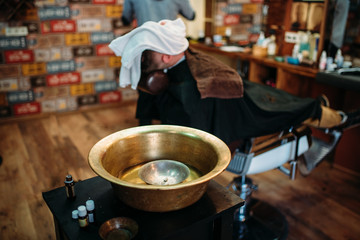 Basin and shaving tools on the table at barbershop