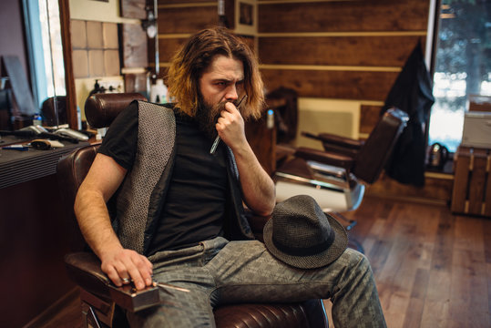 Bearded barber sitting in a leather chair