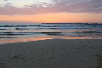 sunset on Weligama Bay Beach with silhouette people in the sea, Sri Lanka