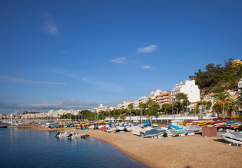 Fototapeta na wymiar Blanes Beach With Motorboats and Kayaks on Costa Brava in Spain