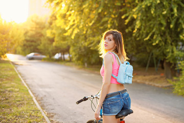 beautiful slender young woman in shorts and sport top stands wit