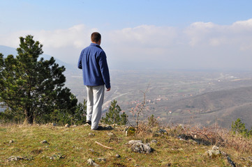 Young man  standing on top of the hill over the city