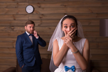Surprised bride against groom talking on the phone