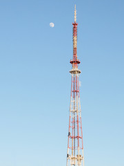 TV tower and moon against the blue sky
