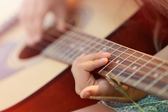 Girl playing guitar, closeup