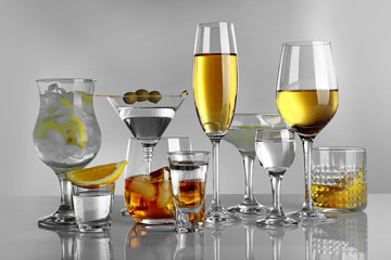 Glasses of wine and spirits on light background