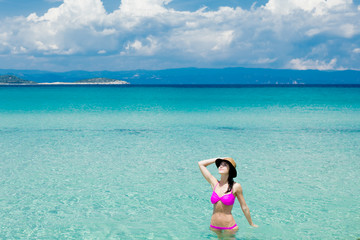 beautiful young woman standing in the wonderful clean sea in greece