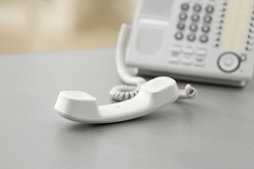 Telephone with picked up receiver on table in office