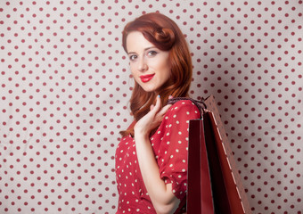 beautiful young woman with shopping bags  standing in front of the wonderful dotted background