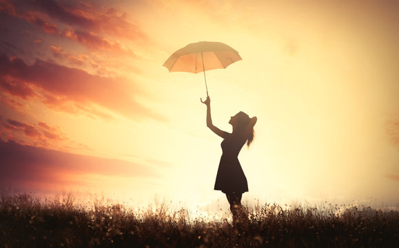 shadow of a beautiful young woman with umbrella on the wonderful sun background
