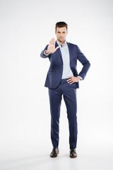 Full length portrait of business man showing stop sign