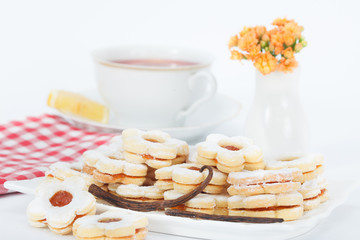 Vanilla jam cookies with cup of tea and lemon slice