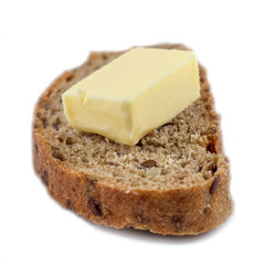 Dark rye bread with seeds and butter on white background