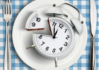 Time to meal concept, cut clock on plate. top view