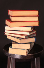 A stack of books on a wooden stool