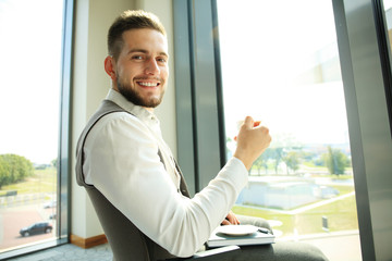 Fototapeta premium Businessman having a coffee break and relaxing at window