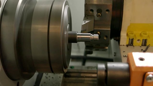 Metal turning lathe in action. Production of steel detail. Precision of cnc machine.