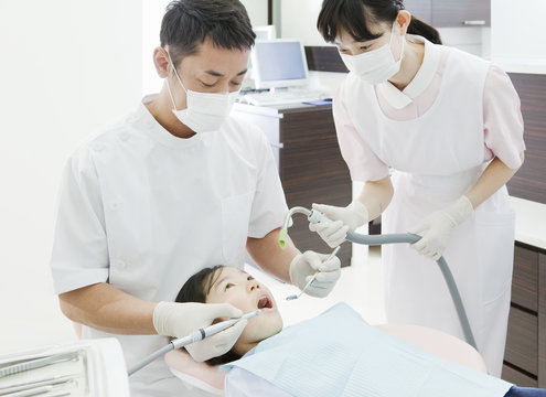 Dentist and Dental Assistant Giving a Girl Dental Treatment