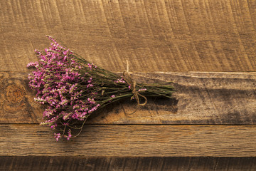 Bundle of small pink flowers on wood background
