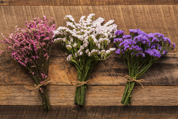 Three bundle of small  flowers on wood background
