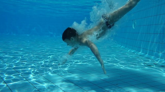 Boy in swimming pool swim underwater