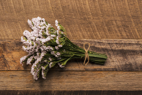 Bundle of small pink flowers on wood background